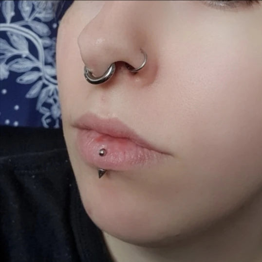 Titanium septum piercing, symbool van feestelijke weerstand.