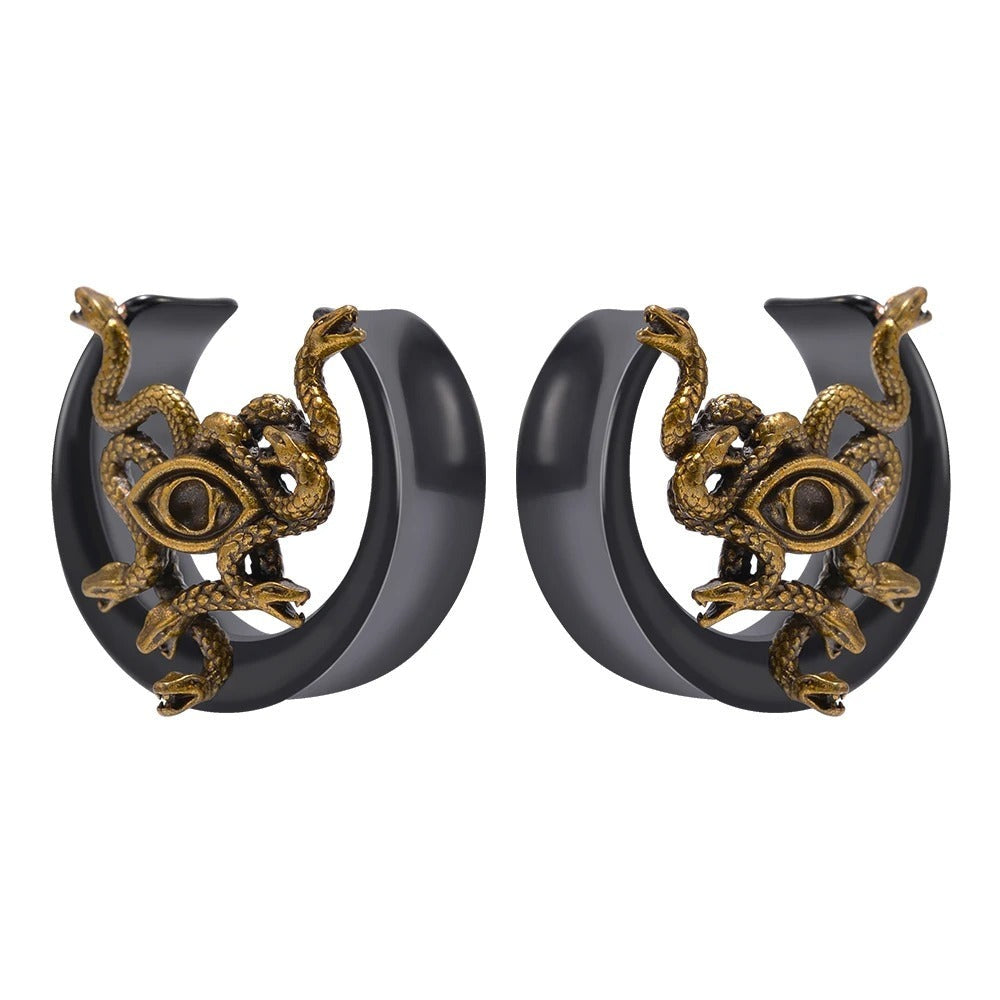 Plug van een oor in zwart met een gouden slang om een oog gewikkeld, vooraanzicht.