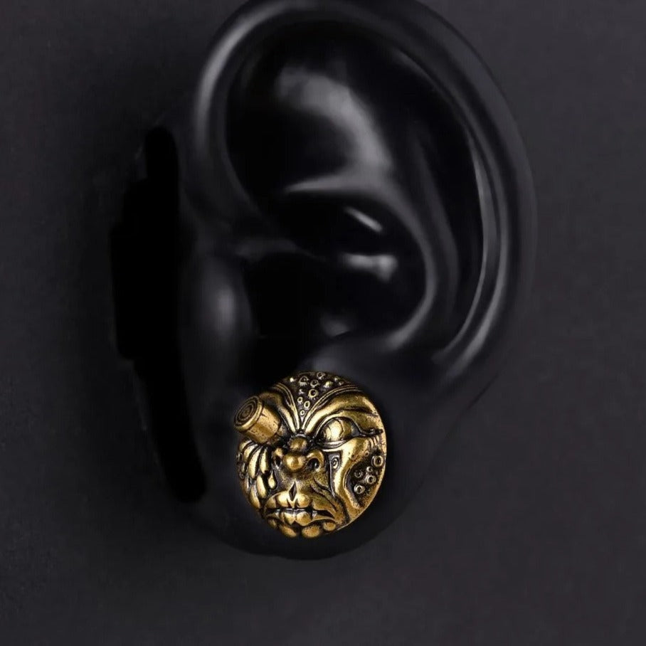 Oorpluggen beschikbaar in goud, met een expressief gezichtsontwerp.