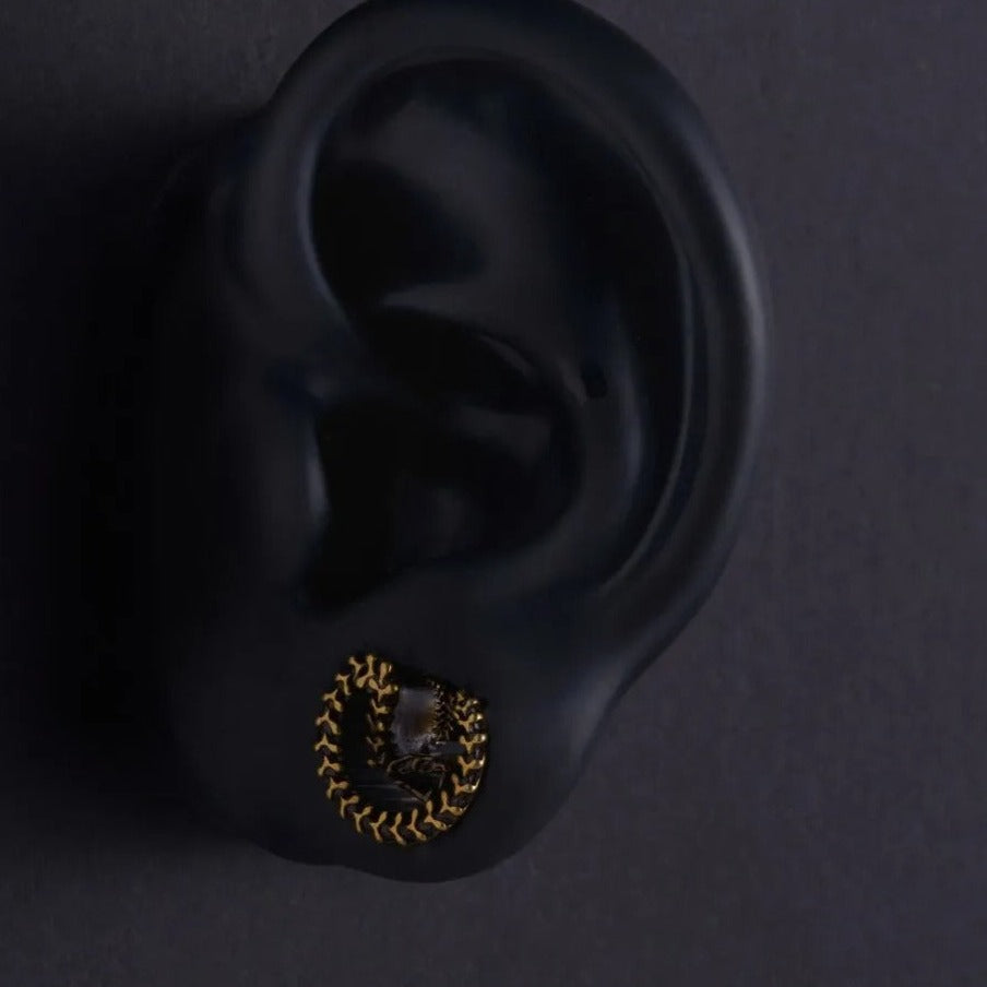 Oorpluggen met reliëfslang, beschikbaar in goud en zilver.