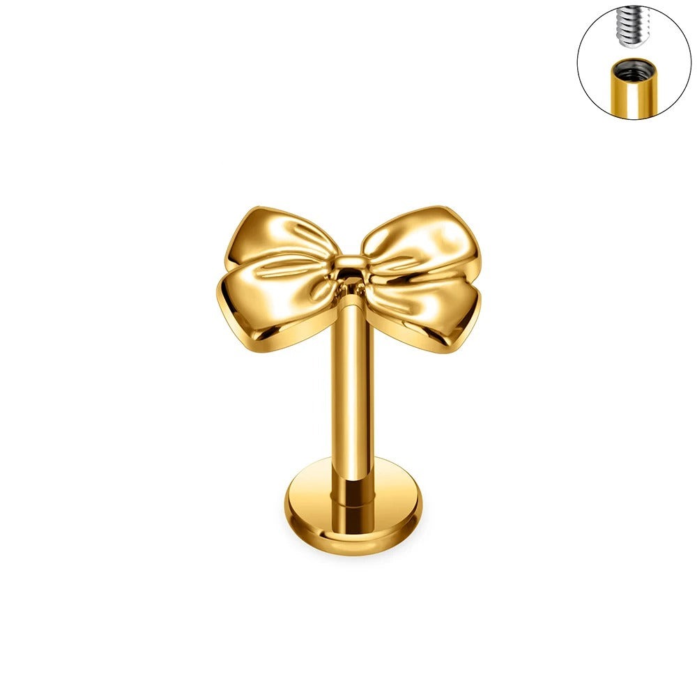 Gouden oorpiercing met strikje.