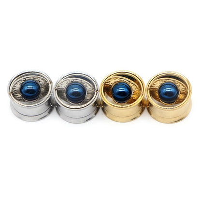 Gouden oorverbreder met centrale blauwe steen.